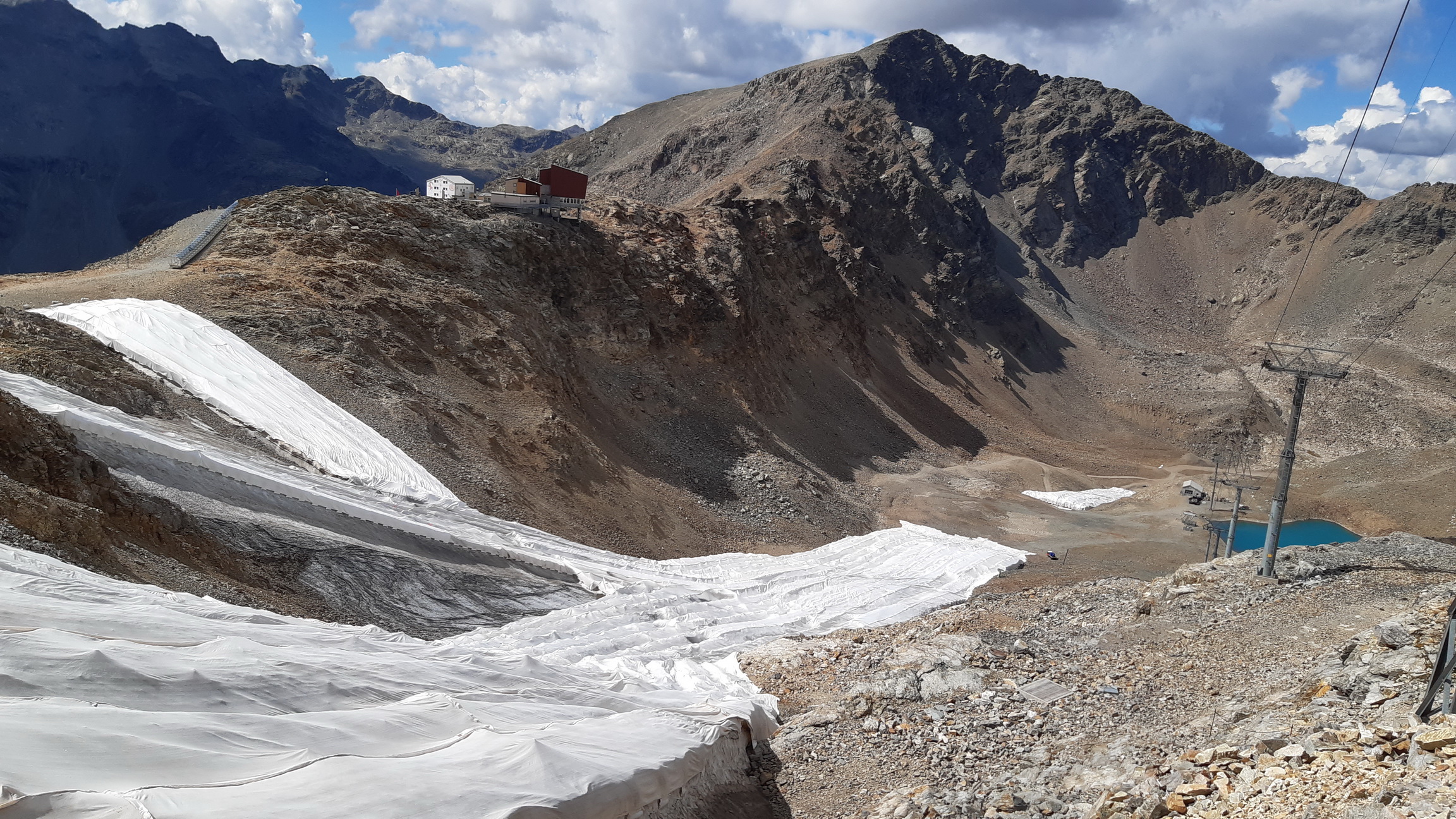 zásoby_snehu_ukryté_pod_plachtou,_Munt_Pers_v_pozadí